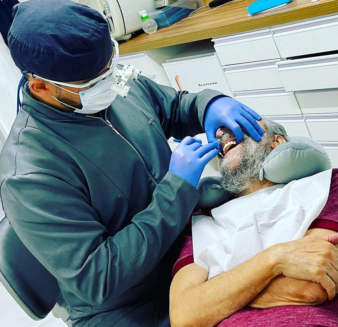 Dr. Marcos Calixto atendendo paciente com lupa odontológica